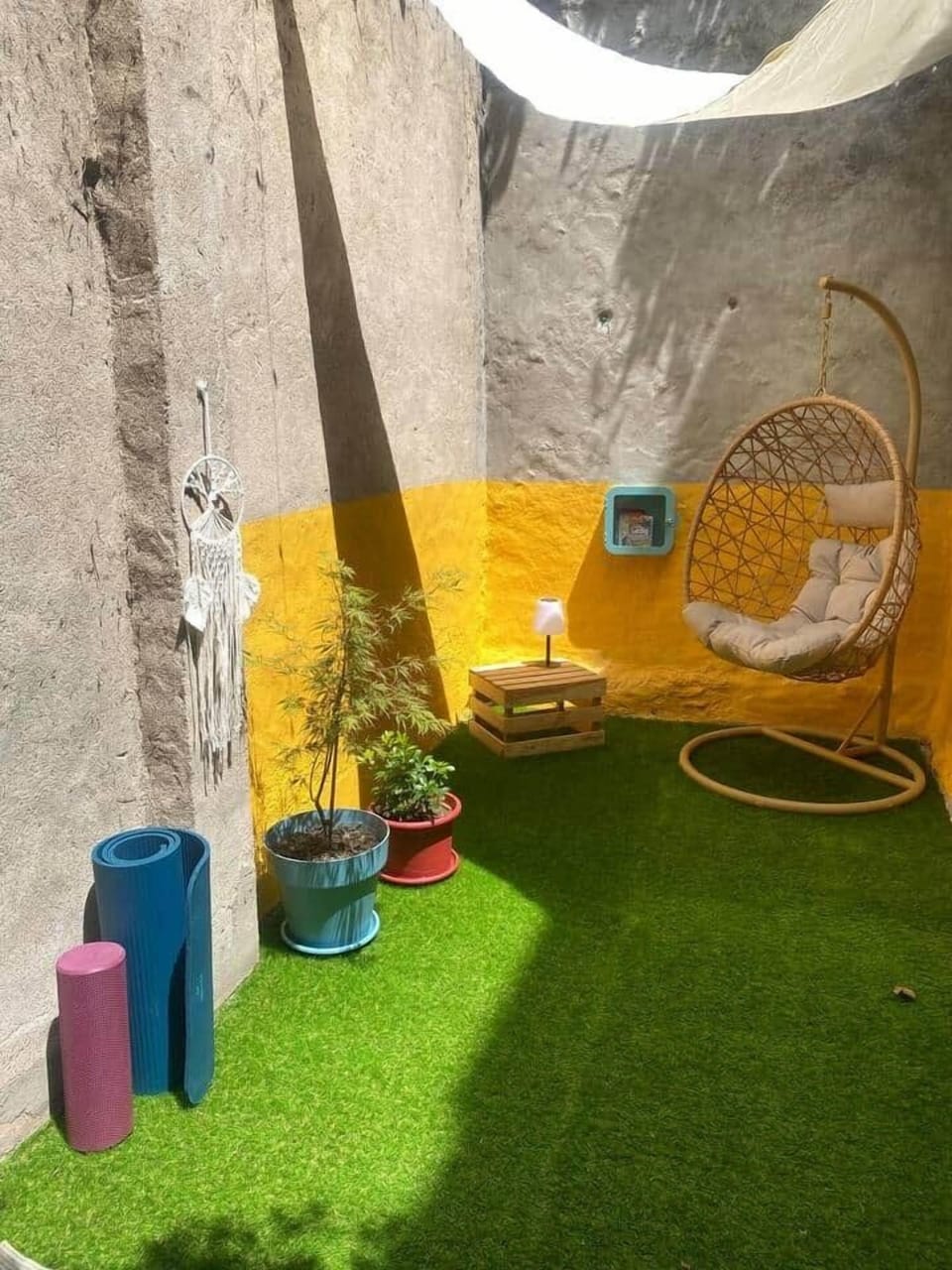 Cozy outdoor seating area with colorful decor and lush greenery in a serene garden setting