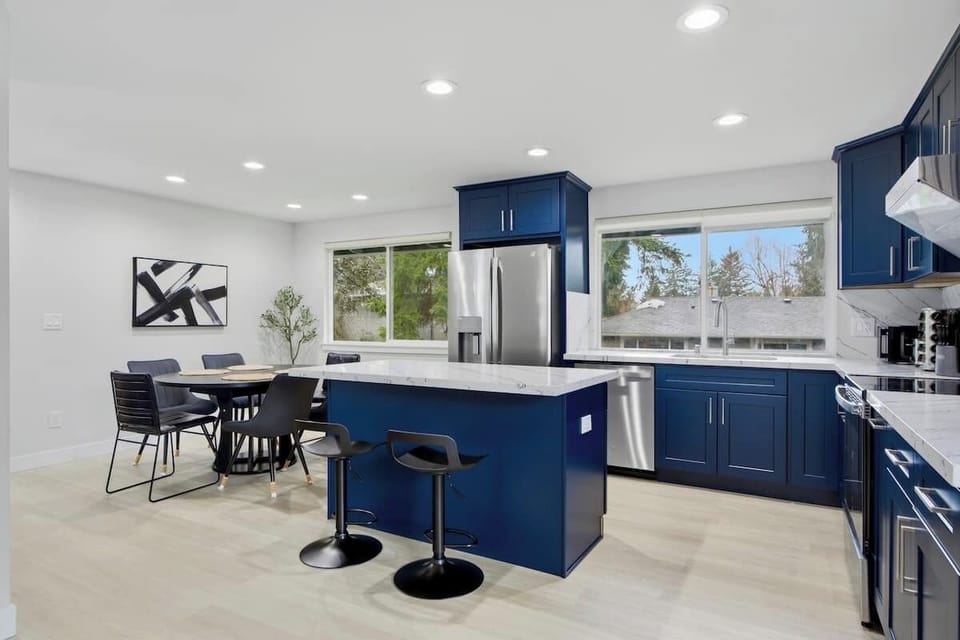 Fully equipped kitchen with island, dining area, and stainless appliances