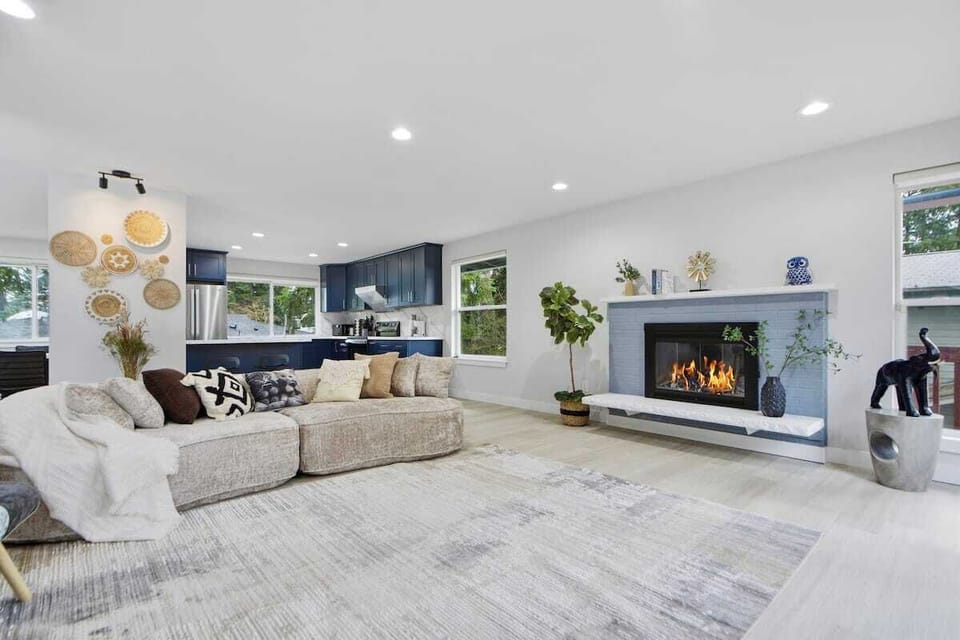 Spacious living area with decorative fireplace and open kitchen view
