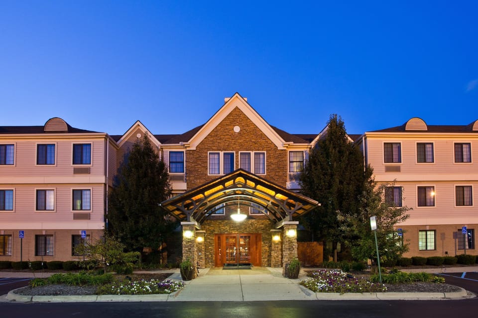 Exterior view of the hotel building with the main entrance and complimentary parking lot