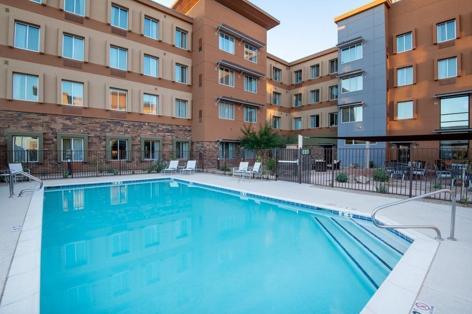 Outdoor pool with gray lounge chairs along the tiled deck