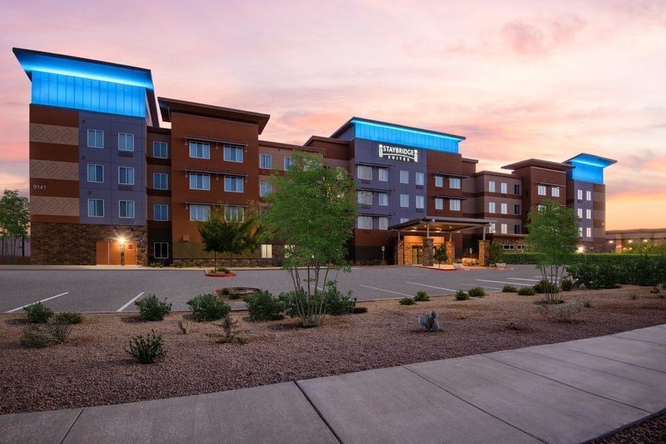 Hotel exterior at dusk with blue accent lighting along the roofline and landscaped entry