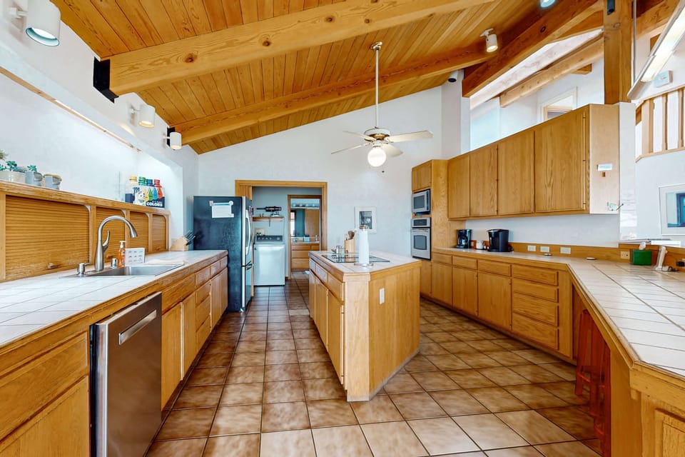 Unleash your culinary creativity in this spacious kitchen, where ample counter space and natural light inspire delicious meals with ocean views.