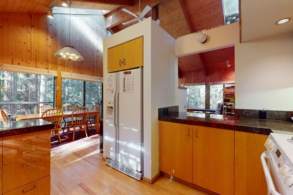 An open design of the kitchen flows seamlessly into the dining area, making it easy to entertain while enjoying the forest views.