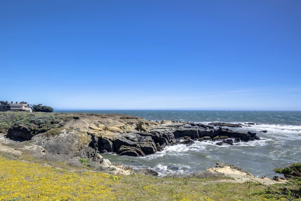 Marvel at the dramatic coastline, where golden wildflowers meet the rugged cliffs, creating an idyllic backdrop for your outdoor adventures.