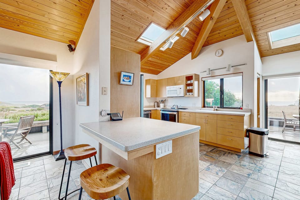 Cook up your favorite meals in the open kitchen, featuring a breakfast bar, skylights overhead, and ocean views that keep you connected to the coast.