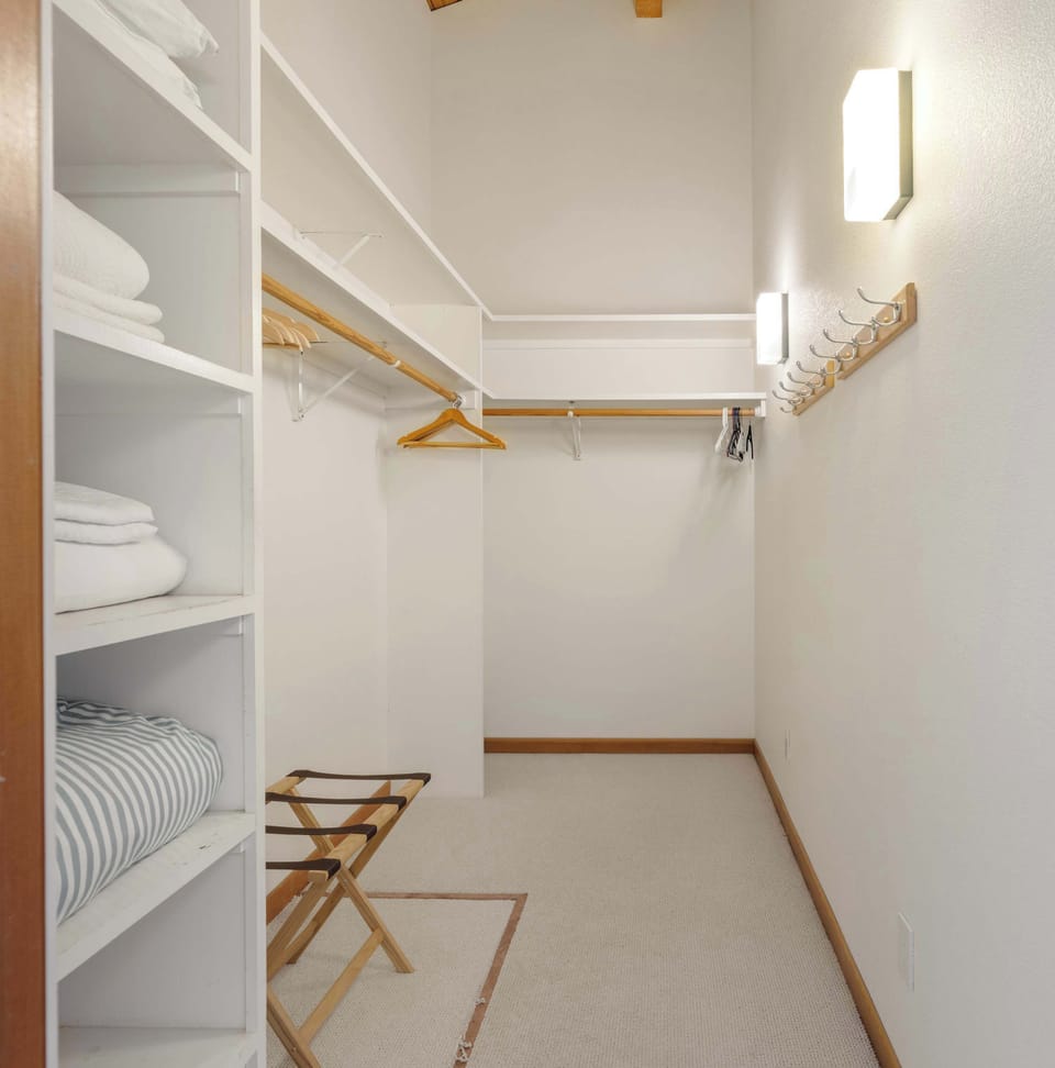 A spacious walk-in closet with shelving, a luggage rack, and plenty of hanging space keeps your belongings organized during your stay.