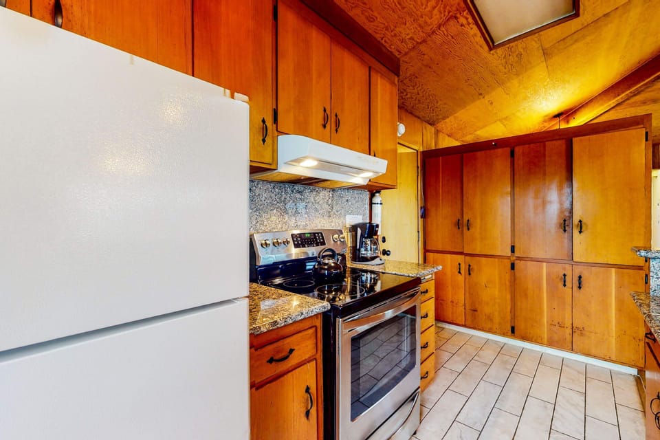 Prepare your favorite dishes in this charming kitchen, featuring ample counter space and scenic views to inspire your culinary creations.