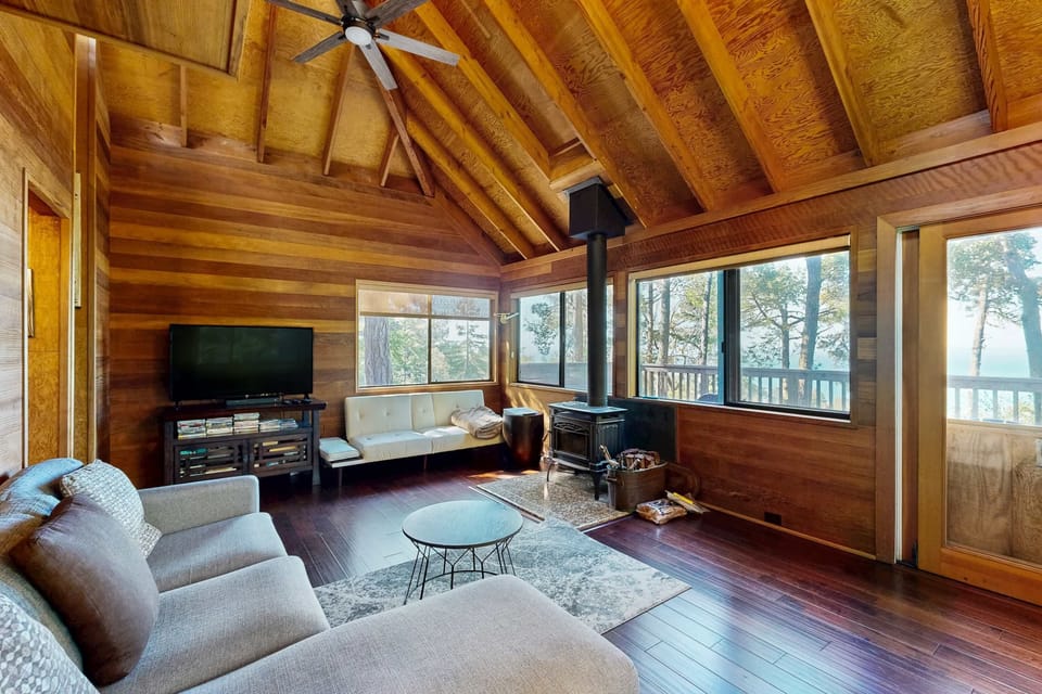 Morning light fills this cozy living room, inviting you to curl up with a book or enjoy the ocean views through expansive windows.