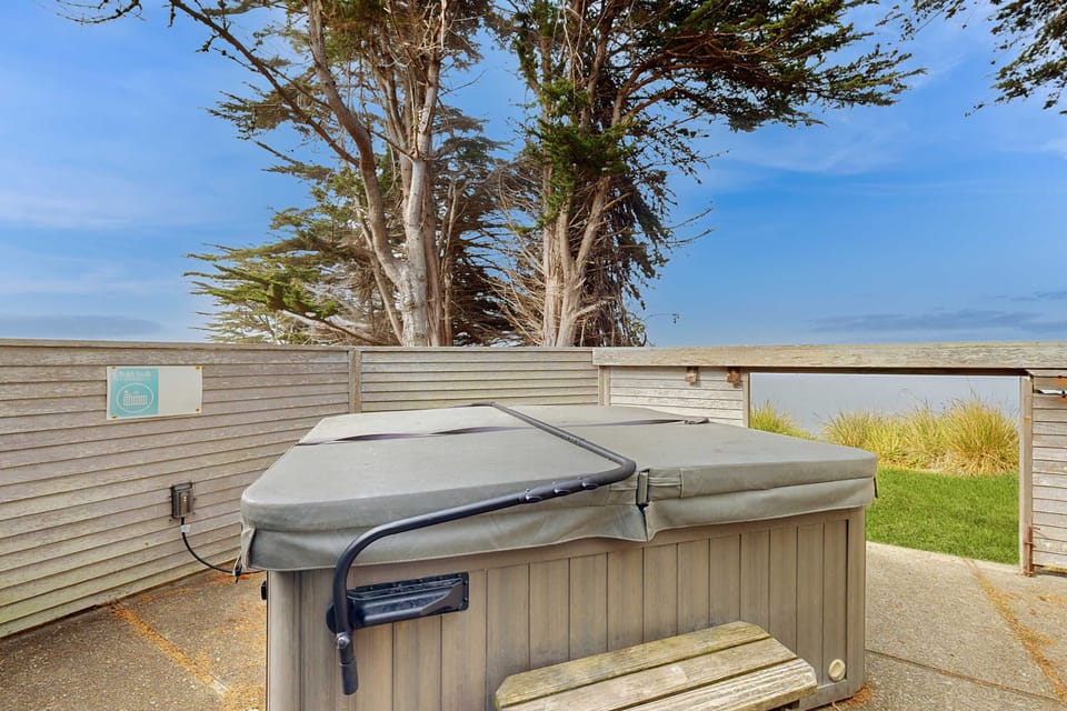 Indulge in a soak under the stars in your private hot tub, the ultimate way to unwind after a day of seaside adventures.