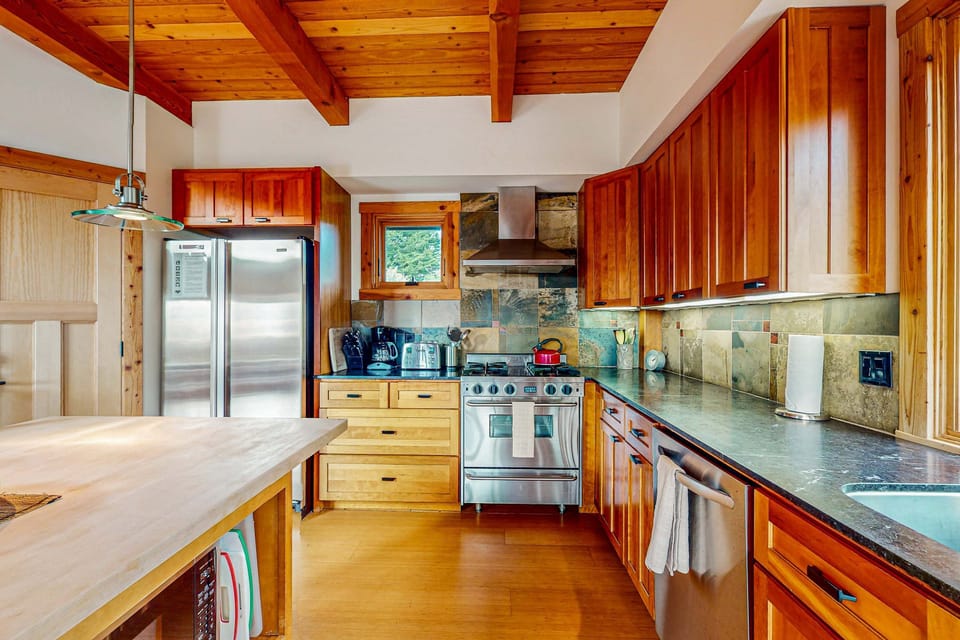 Cook with joy in this stylish kitchen, where rich wooden cabinetry meets modern amenities, making it a delight for any home chef.