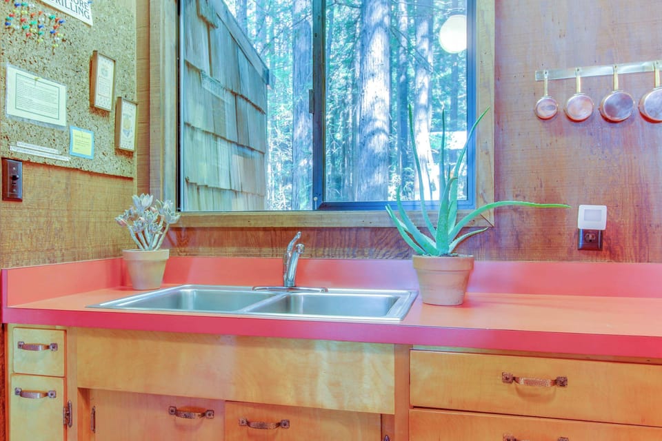 Enjoy the practicality of this kitchen, where sleek counters and views of the towering trees keep you connected to nature.