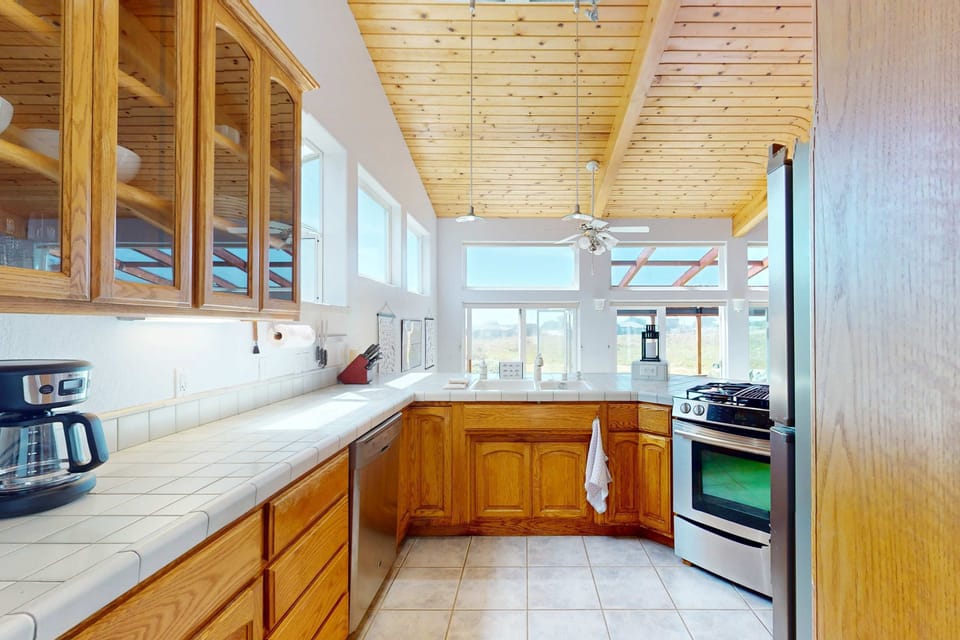 The kitchen's sleek design and functionality make preparing meals a joy, with ocean views to keep you inspired.