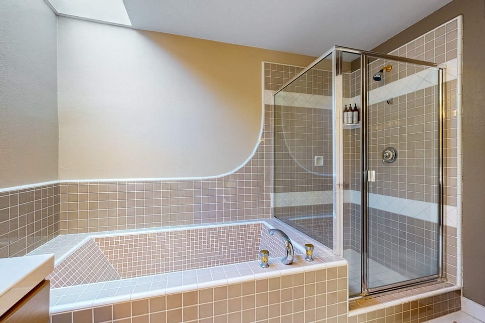 Indulge in a spa-like experience in this inviting bathroom, where natural light enhances your moments of relaxation after a day of coastal adventures.