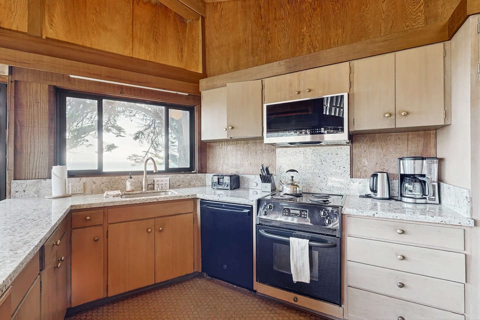 Craft culinary delights in a well-equipped kitchen, designed for both functionality and stunning coastal views.