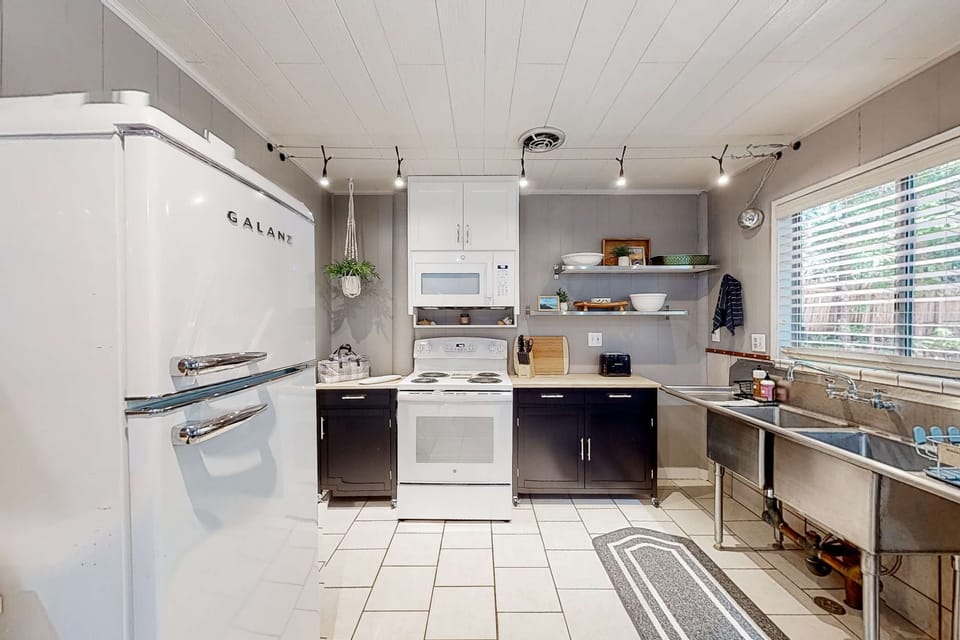 The kitchen’s retro charm invites you to whip up delicious meals while soaking in the cozy atmosphere, making every culinary moment memorable.