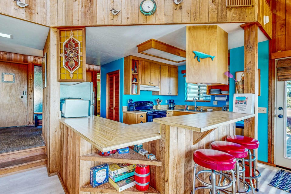 The kitchen's vibrant blue accents add a splash of color, creating an inviting atmosphere where you can whip up culinary delights and enjoy quality time.