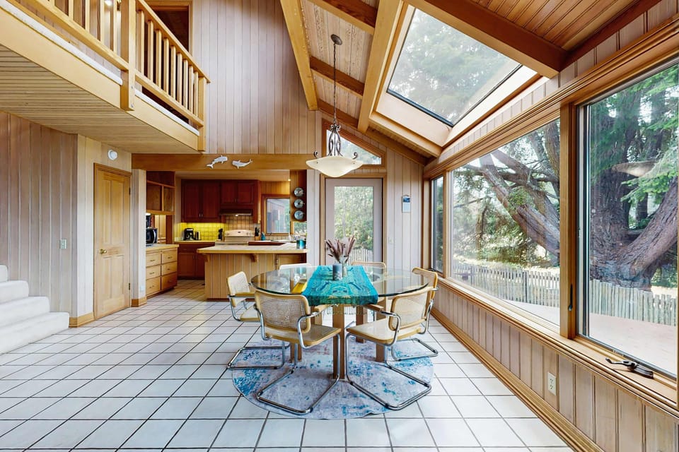 Dine with a view in this sunlit dining area, where large windows invite the beauty of nature inside for memorable meals with loved ones.