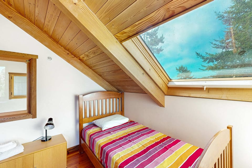 This cozy bedroom, with its charming skylight, invites you to unwind in comfort, making it a perfect retreat for dreamers and adventurers alike.