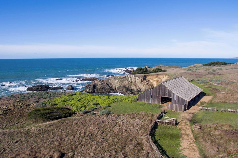 Discover the charm of the coastline as you stroll past this rustic building; the ocean waves and scenic trails are just steps away.
