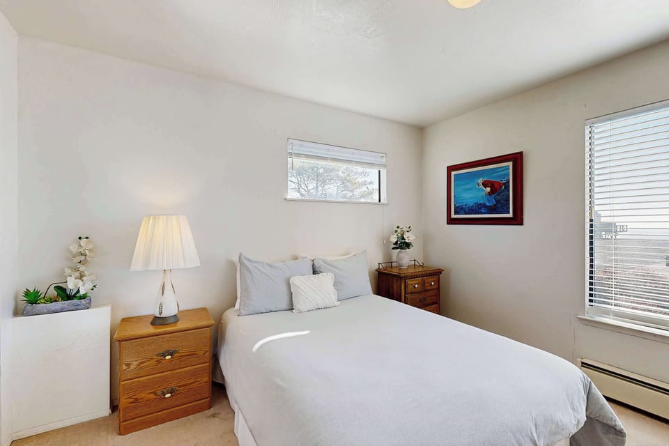 Fresh white linens, a bedside orchid, and natural light -- the guest bedroom is a quiet retreat after a day on the coast.