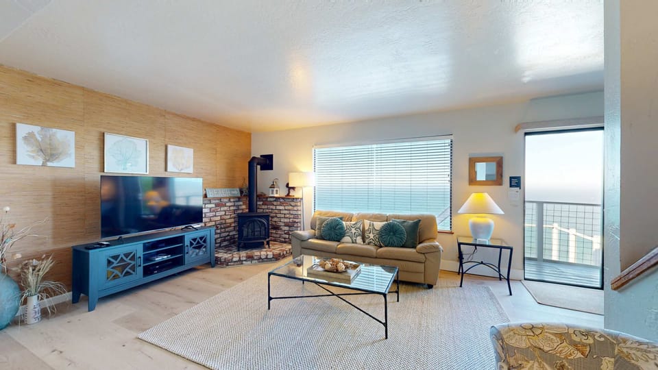 A big-screen TV, gas fireplace, and bamboo accent wall give the living room a laid-back coastal feel -- the sliding glass door puts the ocean one step away.