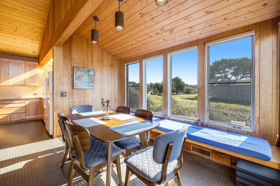 Start your day with sunshine pouring in through expansive windows in this cozy dining nook, perfect for morning coffee and ocean views.