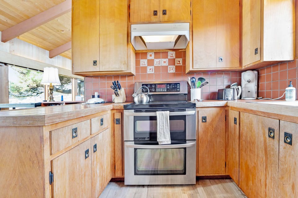 Cook with ease in this charming kitchen, featuring modern appliances and a warm, inviting atmosphere for culinary adventures.