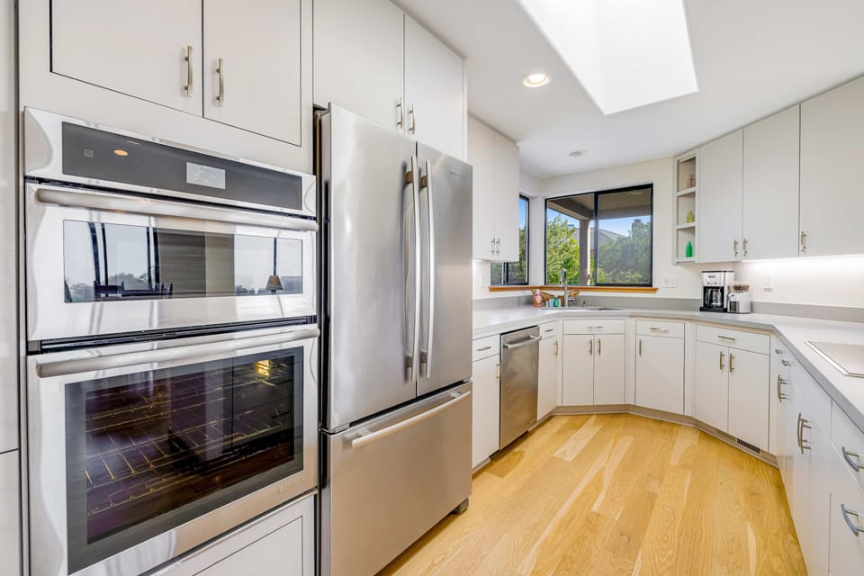 Your sleek kitchen awaits culinary creations, featuring ample counter space and modern appliances for effortless meal prep.