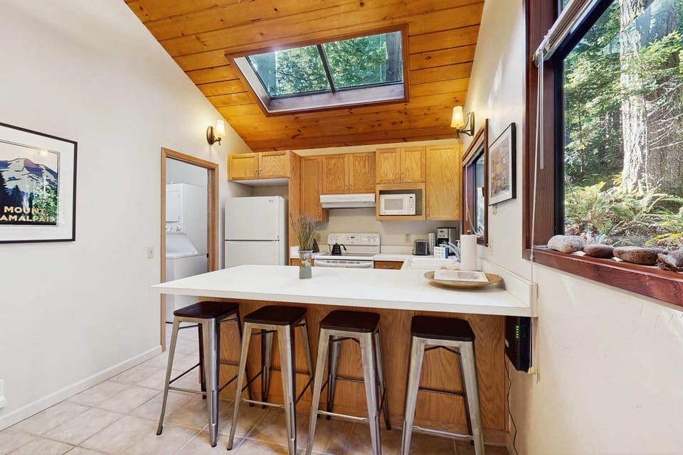 Craft delicious meals in this well-equipped kitchen, where natural light pours in, inspiring culinary creativity surrounded by nature.