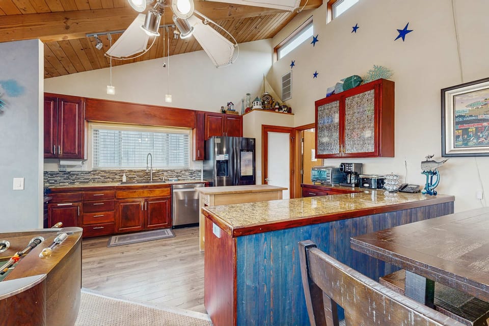 The kitchen's vibrant decor and modern appliances inspire creativity, making it easy to whip up delicious meals during your coastal retreat.