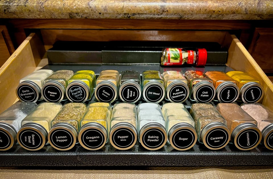 Labeled spice jars fill the pull-out drawer — everything you need for a full pantry without hunting through cabinets.