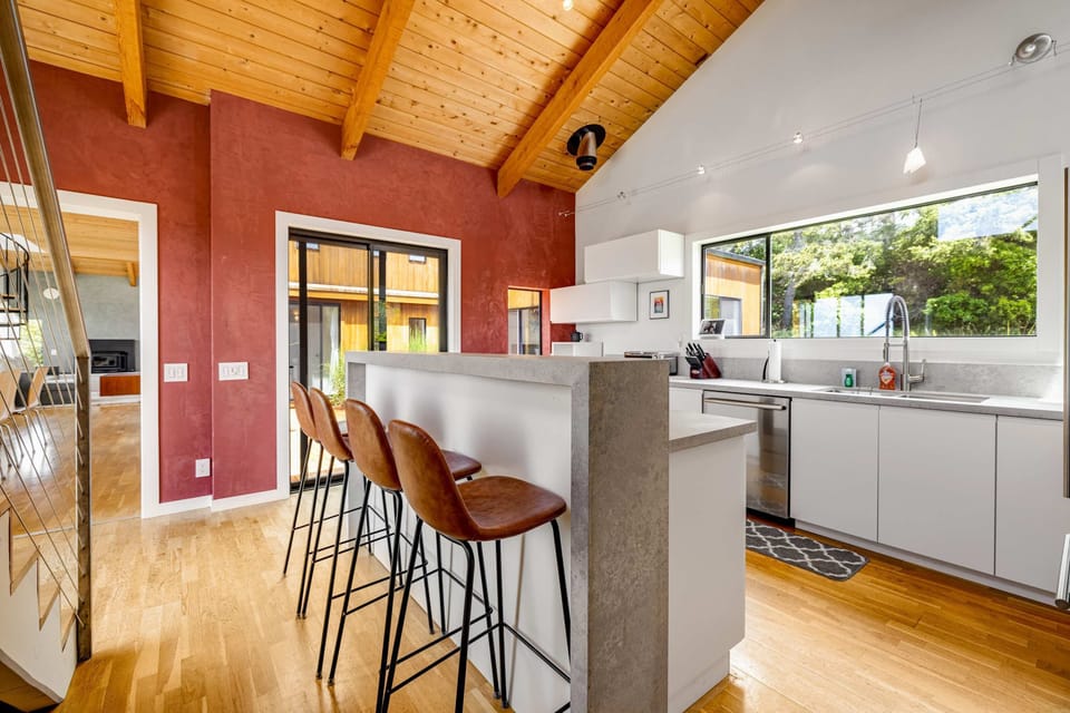 Gather around the sleek breakfast bar in this modern kitchen, where culinary adventures await just a few steps from the dining area.