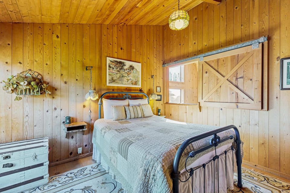 This cozy bedroom invites you to relax, with its warm tones and unique details, perfect for peaceful nights in Sea Ranch.
