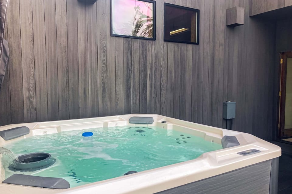 Soak your cares away in the private hot tub, nestled in a serene outdoor setting, ideal for stargazing on clear nights.