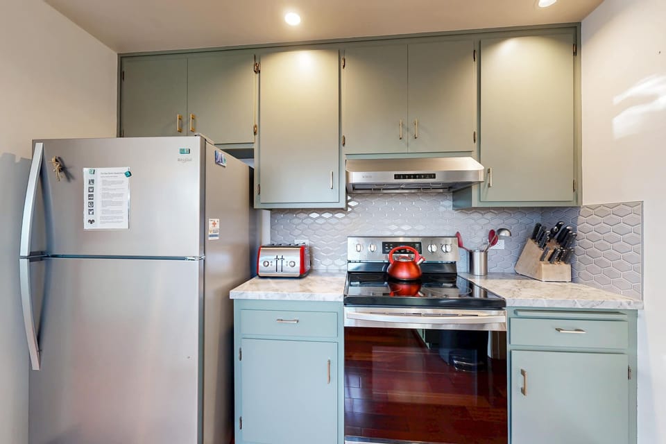 Step into a stylish kitchen where sleek appliances and charming decor create an inviting space for shared culinary adventures.