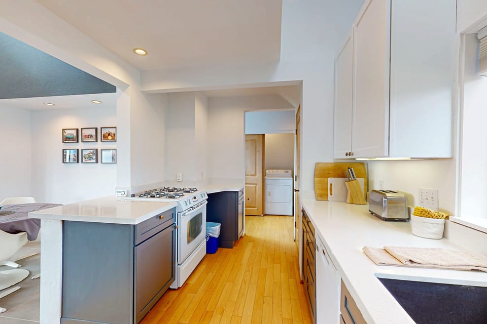 Experience the joy of cooking in this spacious kitchen, where natural light and sleek design create an inviting atmosphere for culinary creativity.