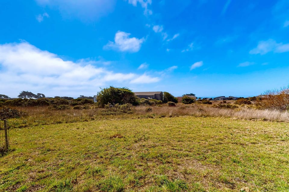 Gaze across the open fields towards the ocean beyond; this tranquil view invites you to explore the natural beauty of Sea Ranch.