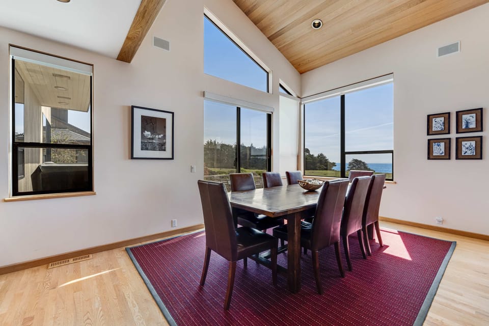 Elevate your dining experience in this sunlit space, where floor-to-ceiling windows invite the beauty of the outdoors in.