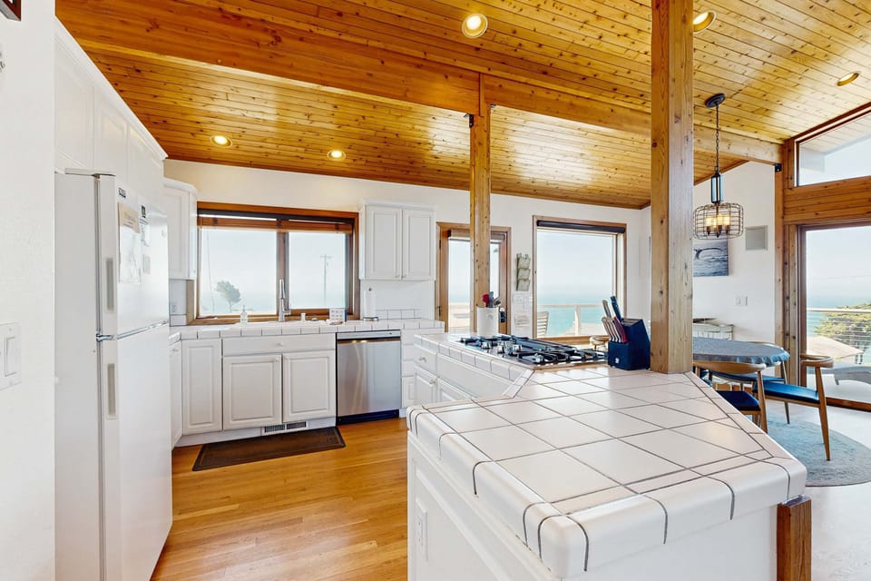 Craft culinary delights in this sunlit kitchen, where stunning ocean views inspire your inner chef.