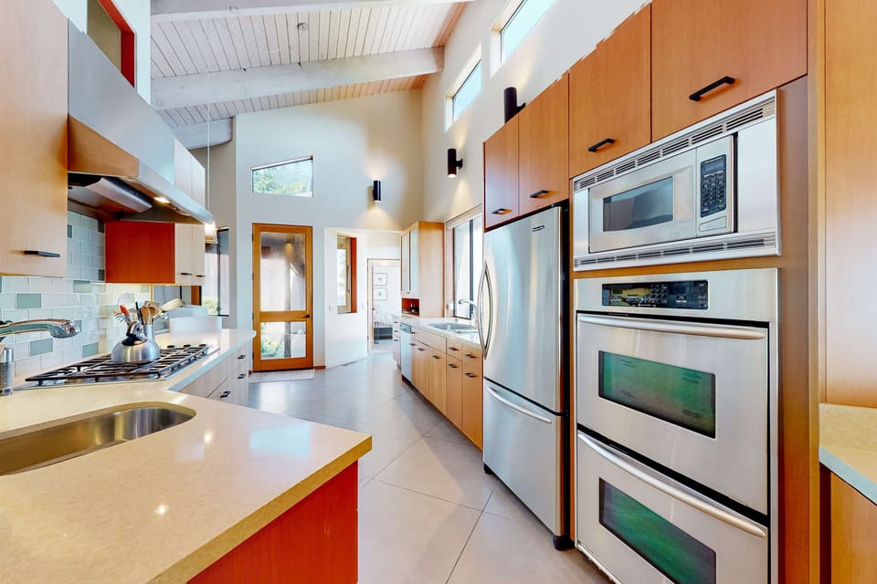 Unleash your culinary creativity in this modern kitchen, equipped with high-end appliances, where meal prep becomes a delightful experience with ocean views.