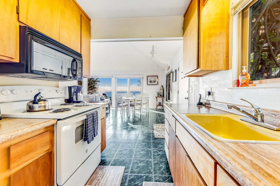 Enjoy the convenience of modern appliances in this cozy kitchen, making meal prep a delightful part of your seaside retreat.