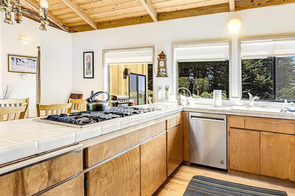 This functional kitchen offers everything you need, with windows framing the serene coastal landscape.