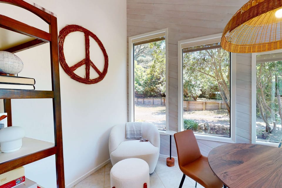This inviting dining area serves as a peaceful retreat, surrounded by windows that let in the beauty of nature while sharing meals.