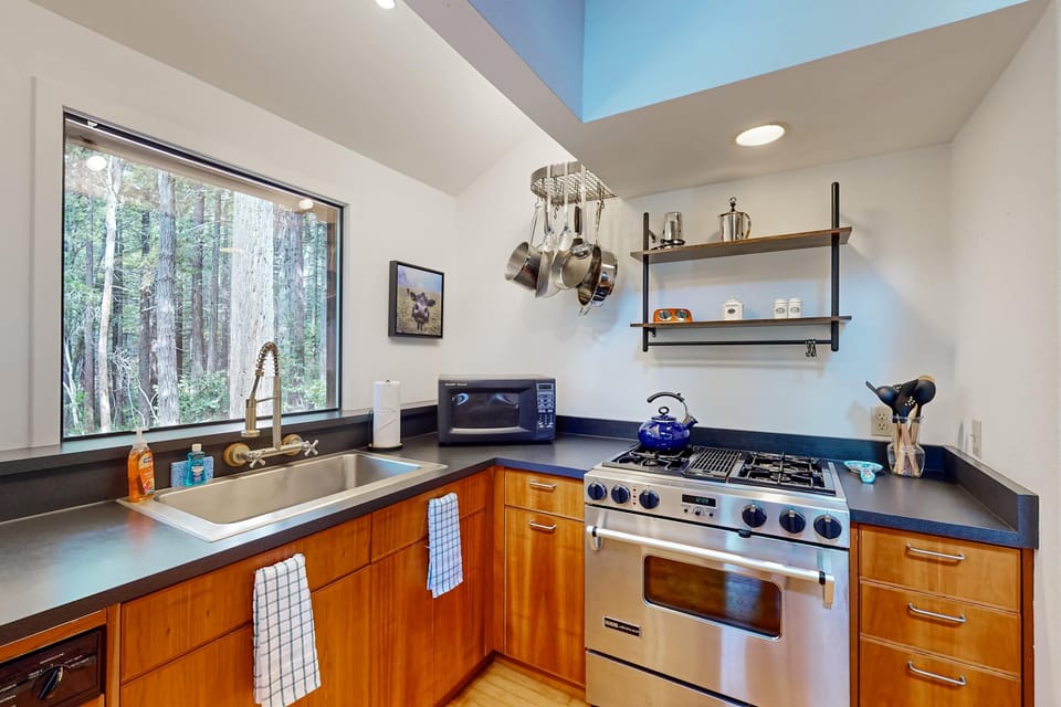 Craft culinary delights in this stylish kitchen, where modern amenities meet the tranquility of nature just outside your window.