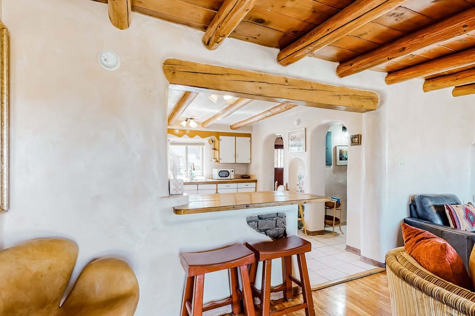 A breakfast bar connects the living room and kitchen