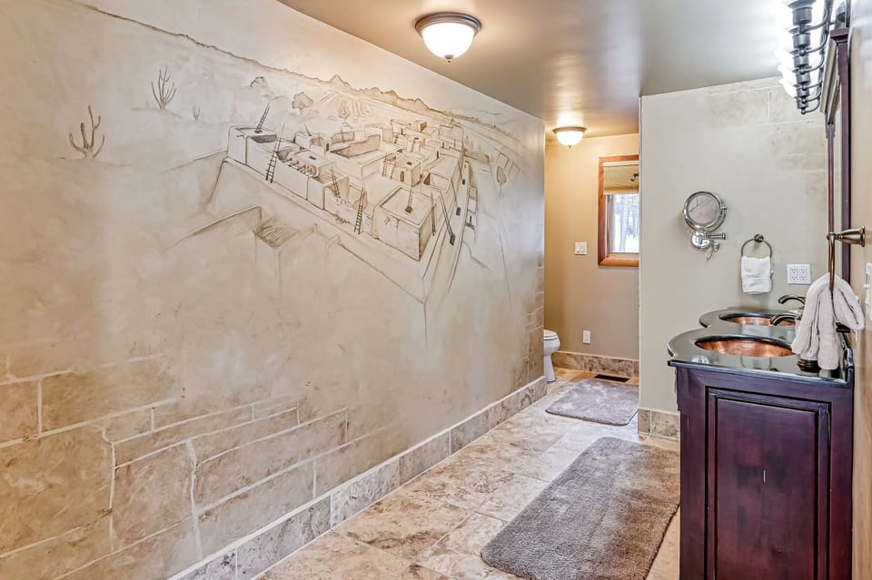 Admire the hand-carved Pueblo mural above dual copper sinks