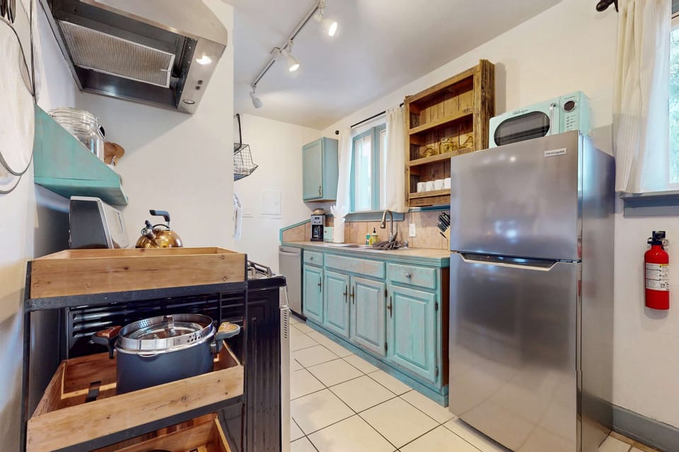 Cook in the full galley kitchen with a stainless gas range and dishwasher