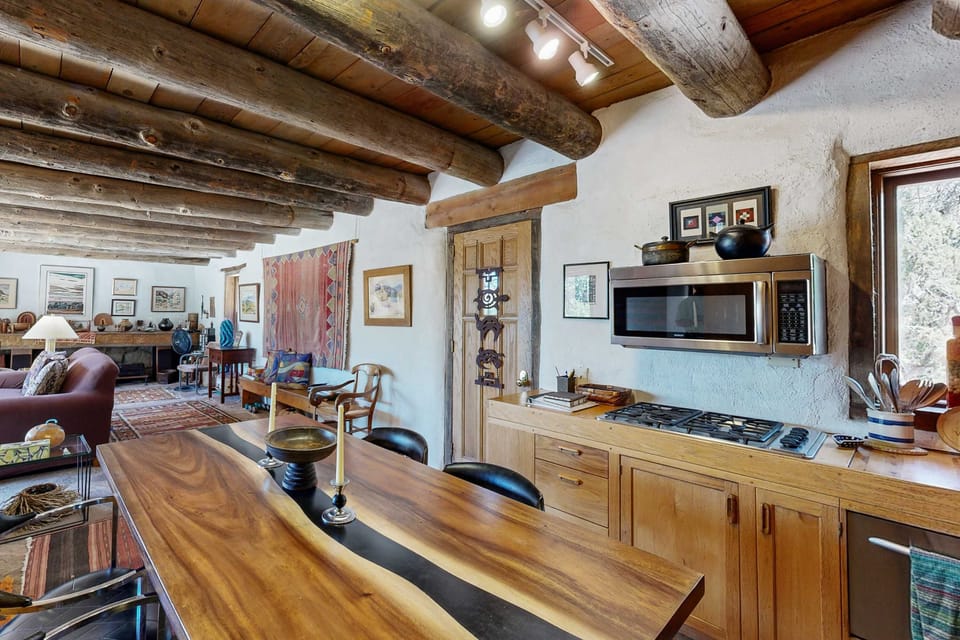 Gather around the dining table beneath exposed vigas