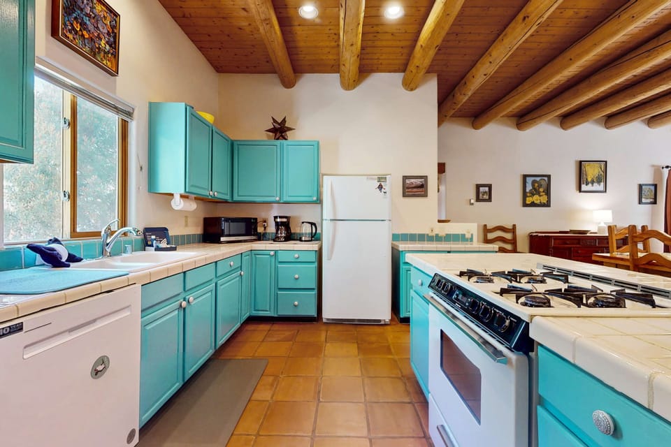 Cook in the cheerful turquoise kitchen with a gas range